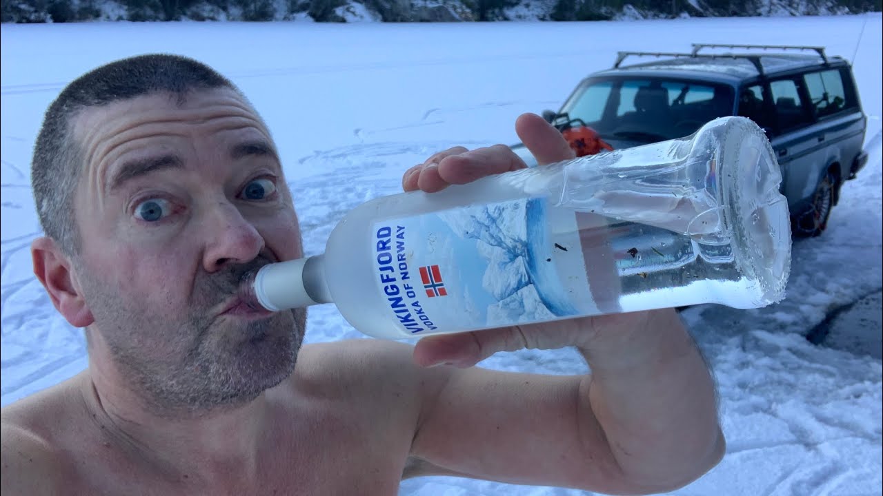 Скриншот из видео с Ютьюб-канала apetor, где он пьёт водку с горла на фоне заснеженного озера. apetor — мужик из Норвегии, который просто снимает влоги, где купается в одних трусах зимой в проруби, и издаёт смешные звуки.